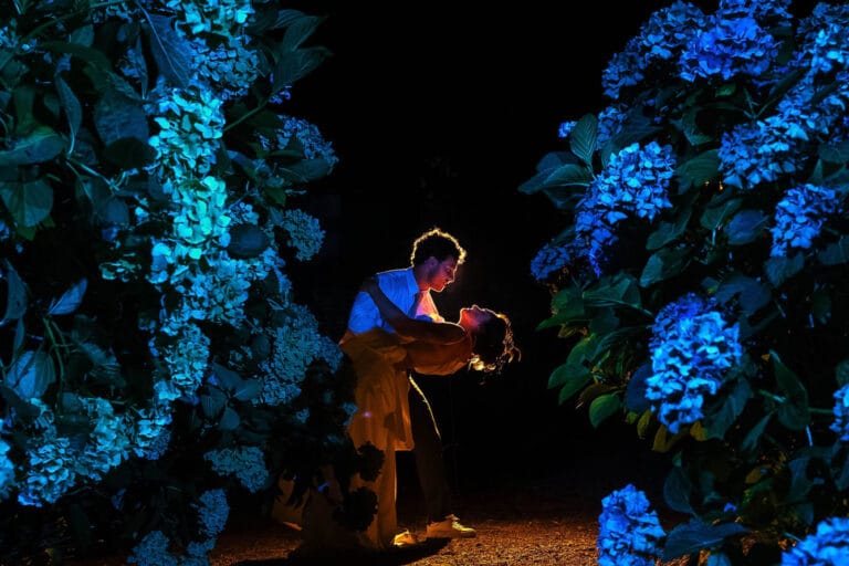 Un couple danse enlacé au milieu des hortensias illuminés, un soir de mariage à Mareuil