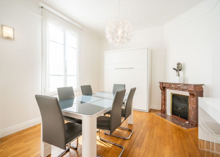 Salle à manger lumineuse avec cheminée et grande table, utilisée pendant les repas collectifs de l’atelier photo-thérapie.