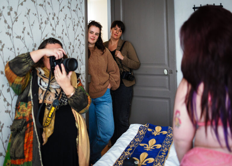 Photographes en observation pendant une séance pratique de photo-thérapie, modèle en pleine pose.